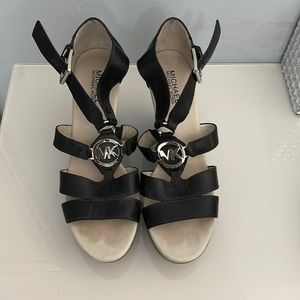 Michael Kora black leather and silver logo/emblem wedge heel sandals size 10